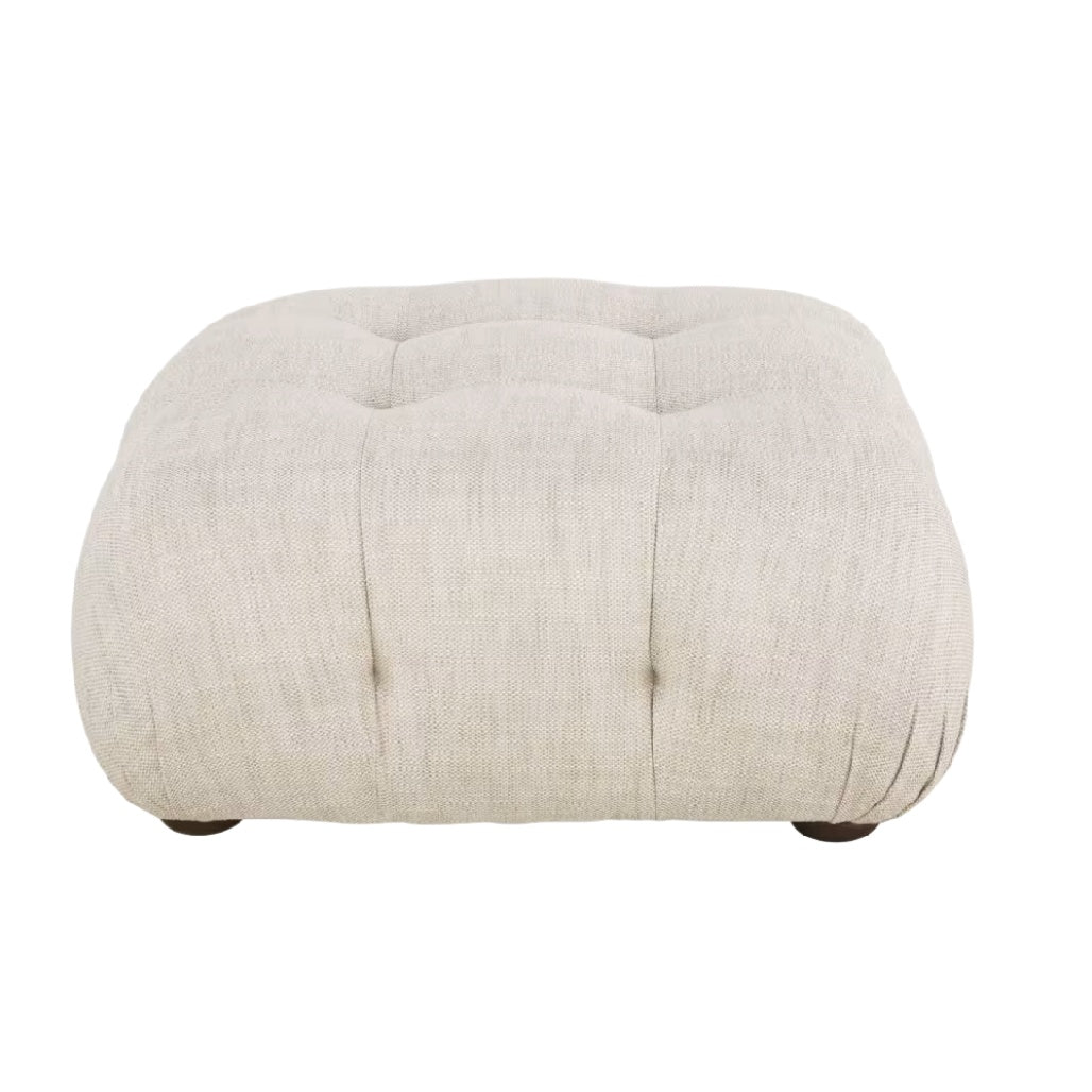Pouf en tissu beige avec capitonnage et pieds en bois.